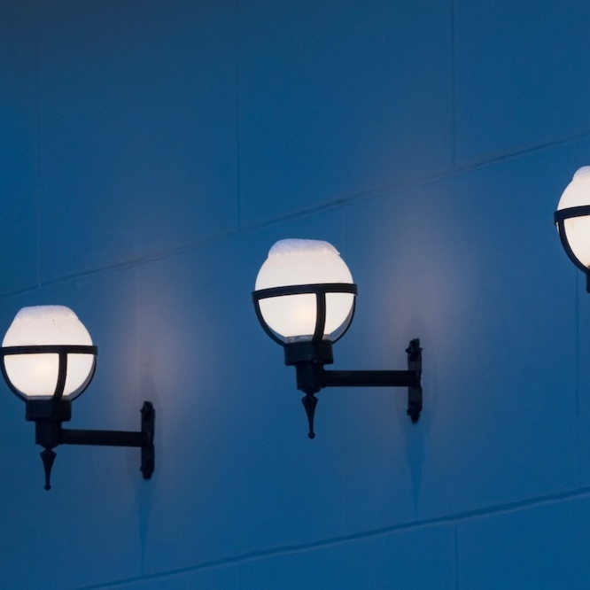 Outdoor lighting depicted with spheres and cast iron holdings.